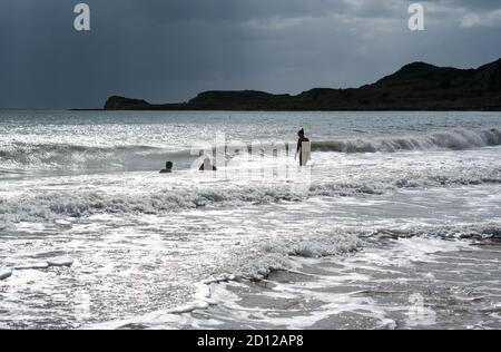 Lixouri, Griechenland. September 2020. Am Strand Xi im Süden der Halbinsel Paliki in Kefalonia am Ionischen Meer schwimmen einige Menschen im Wasser, wenn die Wellen anschwellen und ein Gewitter aufkommt. Quelle: Jens Kalaene/dpa-Zentralbild/ZB/dpa/Alamy Live News Stockfoto