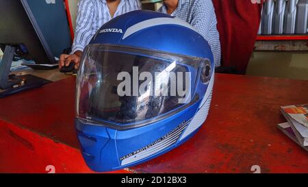 Offener Motorradhelm auf rotem Holztisch. Stockfoto