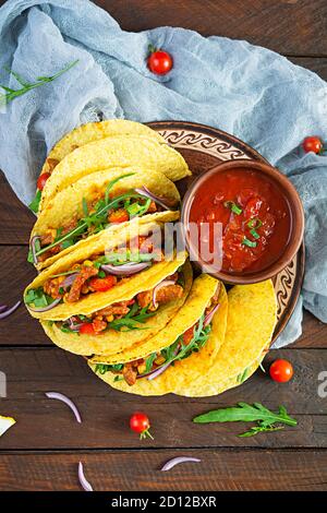 Mexikanische Tacos mit Mais-Tortilla und Fleisch auf Holzhintergrund. Draufsicht Stockfoto