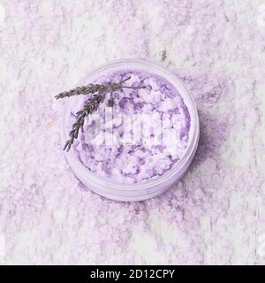 Hausgemachtes Lavendel Körperpeeling in einer Schüssel auf Lavendelbad Salz Hintergrund. Draufsicht, Kopierbereich für Text. SPA-Konzept. Selektiver Fokus Stockfoto
