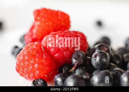 Zwei verschiedene Arten auf Beeren auf weißem Teller Stockfoto