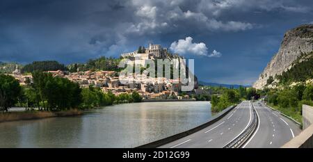 Sisteron und die Zitadelle (Festungen - Historisches Denkmal - Vauban) unter stürmischem Himmel mit dem Durance River. Alpes de Haute Provence, Frankreich Stockfoto