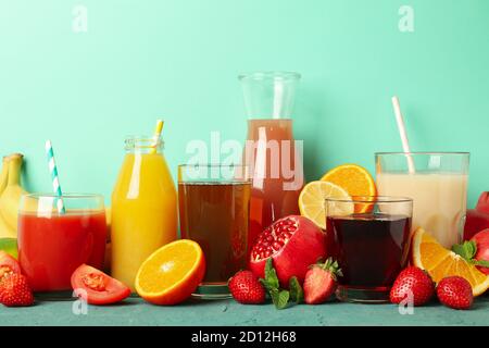 Konzept der Gläser und Flaschen mit verschiedenen Säften auf grün Hintergrund Stockfoto