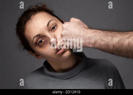 Die Faust eines Mannes trifft eine Frau ins Gesicht. Häusliche Gewalt. Stockfoto