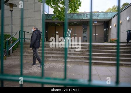 05. Oktober 2020, Hamburg: Am Tag nach dem Anschlag auf einen jüdischen Studenten geht ein Mitarbeiter einer Sicherheitsfirma vor den Eingang der Hamburger Synagoge. Ein Mann im Tarnanzug hatte den Schüler mit einem Spaten angegriffen. Der 29-Jährige soll eine Notiz mit einem Hakenkreuz auf sich getragen haben und scheint verwirrt. Die Polizei ermittelt den Hintergrund des Verbrechens. Foto: Jonas Walzberg/dpa Stockfoto