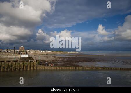 Dramatischer Himmel mit Cumulus und Cumulonimbus Wolke über Littlehampton Seafront bei Ebbe. Stockfoto