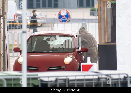 Der Sanitäter trägt eine Schutzausrüstung und testet den Patienten in einem mobilen Test Stationszelt für Autos während Coronavirus oder COVID19 Ausbruch Stockfoto