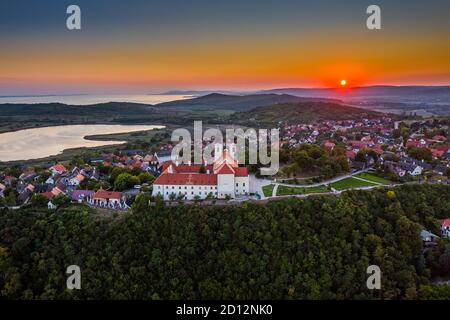 Tihany, Ungarn - Luftpanorama des berühmten Benediktinerklosters von Tihany (Tihany Abtei, Tihanyi Apatsag) mit schönem goldenen Himmel bei Sonne Stockfoto