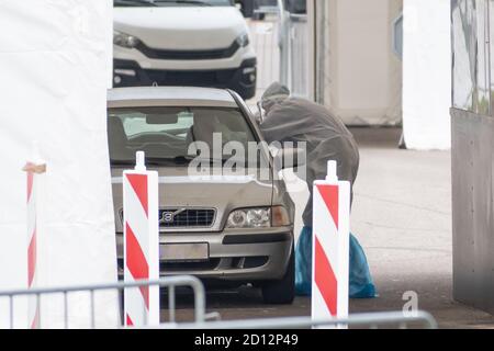 Der Sanitäter trägt eine Schutzausrüstung und testet den Patienten in einem mobilen Test Stationszelt für Autos während Coronavirus oder COVID19 Ausbruch Stockfoto