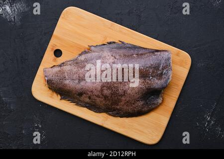 Blick von oben auf rohen frischen Heilbutt ohne Kopf auf Holz Schneidebrett Stockfoto