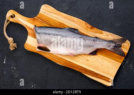 Draufsicht auf rohen frischen kopflosen rosa Lachs auf Holz Schneidebrett Stockfoto