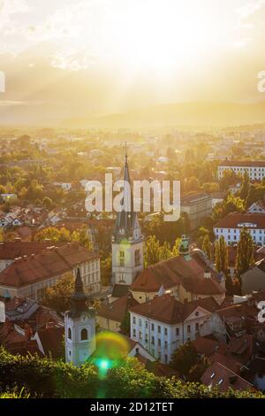 Luftaufnahme der Kirche St. Jakob und des westlichen Teils von Ljubljana von der Burg von Ljubljana während des Herbstuntergangs. Slowenien, Religion, Architektur Stockfoto