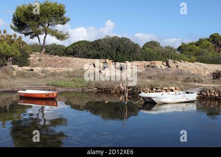 Kleine Boote, die in den Gewässern in der Nähe der berühmten Salzpfannen festgemacht sind Von Trapani Sizilien Stockfoto