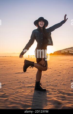 Junge Bohemian Figur Frau Porträt auf einem Spaziergang am Strand Sonnenuntergang. Horizontale Ansicht. Mittlere Aufnahme. Stockfoto