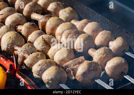 Nahaufnahme der Pilze Spieße, gegrillt in einem Grill in einem Straßenmarkt, Festival, Messe Stockfoto