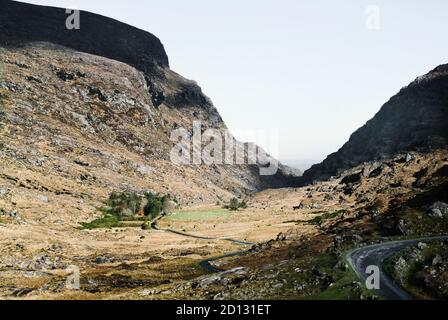 Eine zerklüftete felsige hügelige Landschaft mit Straße in Irland in der Nähe von Killarney. Stockfoto