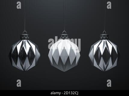 Drei Weihnachtskugeln mit modernem Muster, die auf Saiten vor grauem Hintergrund hängen. Kugeln aus weißem und silbernem Metall. Weihnachtsdekoration, f Stockfoto