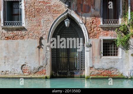 Venedig-Gebäude mit alter Tür für Boote aus Venedig Kanal, Italien Stockfoto