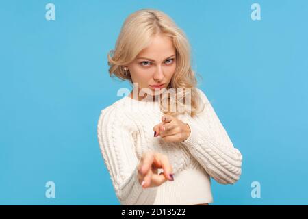 Wütend depressive Frau mit lockigen blonden Haaren zeigt Finger auf Kamera vorgibt, mit der Waffe zielen, bereit, Schuss zu machen, Schwierigkeiten. Innenaufnahme im Studio Stockfoto