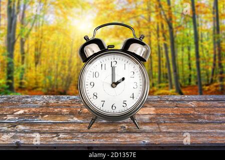 Vintage Uhr im Herbst im Wald. Sommerzeitumstellung Zeitumstellung Konzept Stockfoto