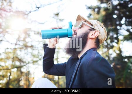 Bärtiger Mann, der nach der Arbeit im Wald Kaffee trinkt Stockfoto