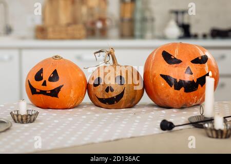 Halloween Kürbis Kopf Jack Laterne mit brennenden Kerzen. Beleuchtete halloween Kürbisse mit Kerzen in der Küche. Stockfoto