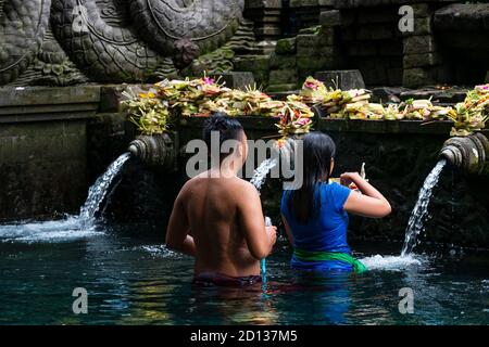 Asien, Indonesien, Bali, Tampaksiring, Kabupaten Gianyar, Tirta Empul Tempel, balinesische hindu-Pilger Baden in heiliger Quellwasser an einem balinesischen Tempel Stockfoto