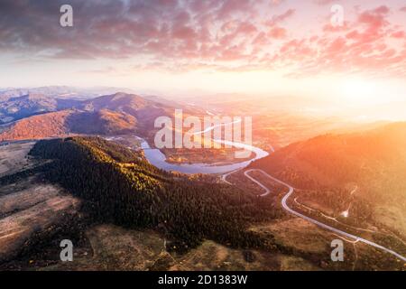 Antenne drone Blick über den Herbst in den Bergen mit Mountain Road Serpentine, Fluss und Wald. Landschaftsfotografie Stockfoto