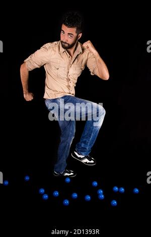 Schöner verspielter bärtiger Mann, der auf einem schwarzen herumläuft Hintergrund Stockfoto
