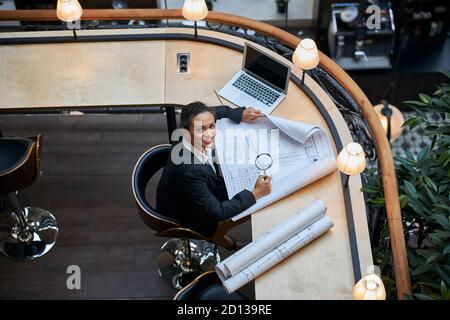 Positive begeistert internationale Frau arbeitet mit Zeichnung Stockfoto
