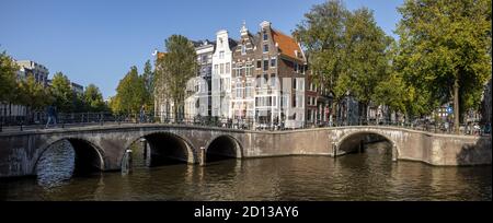 AMSTERDAM, NIEDERLANDE - 22. Sep 2020: Panorama der typischen Amsterdamer Grachtenbrücken und klassischen Außenfassaden historischer Herrenhäuser gegen eine Stockfoto