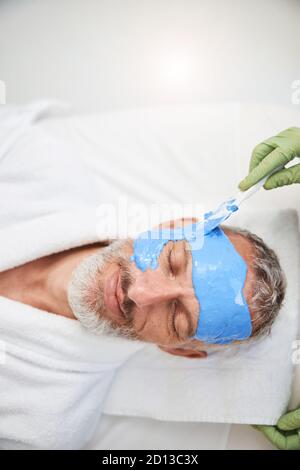 Alternder Mann mit Gesichtsbehandlung in einem Schönheitssalon Stockfoto