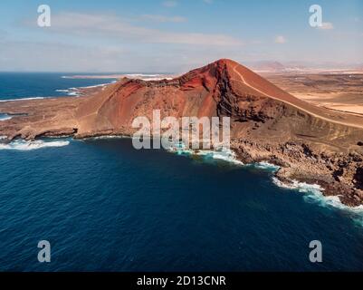 Alter Vulkan mit rotem Felsen und Atlantik bei La Santa, Lanzarote, Spanien. Luftaufnahme Stockfoto