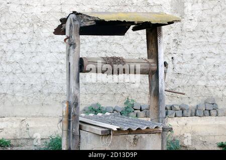 Alter Brunnen auf dem Hintergrund der Wand. Stockfoto