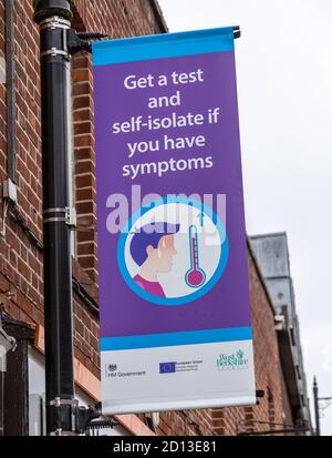 Holen Sie sich einen Test und selbst-isolieren, wenn Sie Symptome haben Covid 19 Informationsposter, Newbury, Berkshire, England, Großbritannien Stockfoto