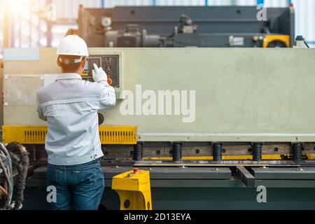 Arbeiter betreibt hydraulische Druckbremse Biegemaschine in der Baufabrik Stockfoto