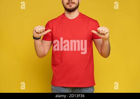 Glücklicher Mann vom Lieferservice in rotem T-Shirt und Mütze Isoliert über gelb Stockfoto