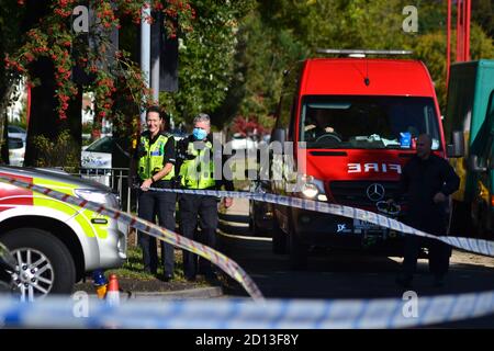 Polizisten und Feuerwehr vor Ort bei einem Vorfall. Polizeiband ebenfalls in Schuss. Zwei Polizisten, männlich und weiblich. Polizei Der West Midlands. Stockfoto