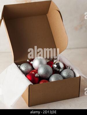 Weihnachtsbaum Spielzeug in einer Bastelkiste. Die Kugeln sind glänzend, rot und silber. Stockfoto