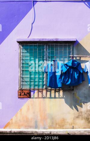 Bambus mit sauberer Kleidung und Graffiti auf dem Wandhaus in der Altstadt von Yala, Südthailand. Stockfoto