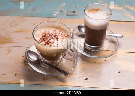 Tassen Cappuccino-Kaffee und Espresso auf Holztisch Draufsicht. Stockfoto