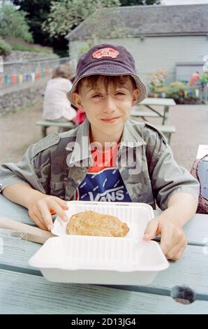 Elfjähriger Junge mit einer kornischen Pasty, Devon, England, Vereinigtes Königreich. Stockfoto