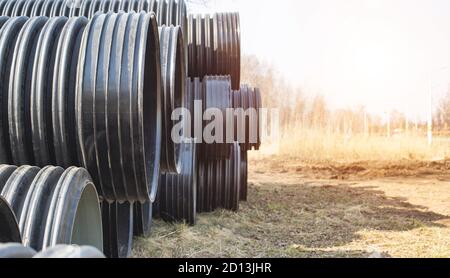 Schwarze Polypropylenrohre mit großem Durchmesser für die Verlegung von Kommunikations-, Entwässerungs- und Heizleitungen unter der Straße. Moderne Methode und Technologie für Stockfoto