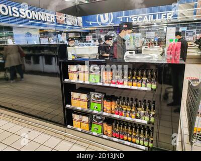 La Rochelle, Frankreich - 3. Oktober 2020:Saucen und frische japanische Produkte im Hypermarkt mit Köchen, die die Gerichte im Hintergrund zubereiten Stockfoto