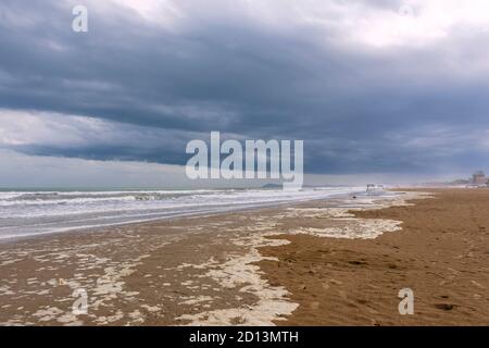 Der lange und breite Strand von Rimini, Emilia Romagna, Italien, unter einem dramatischen Himmel in der Wintersaison Stockfoto