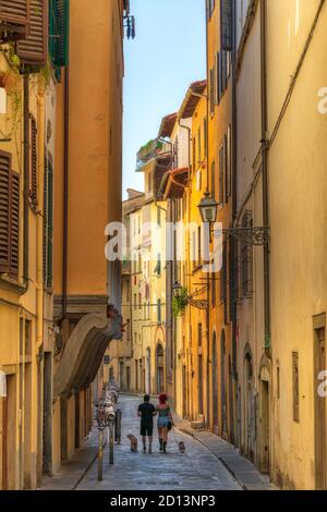 Zwei Menschen, die mit ihren Hunden in der poetischen Via Toscanella, im Herzen des San Frediano Viertels, Florenz Italien, spazieren Stockfoto