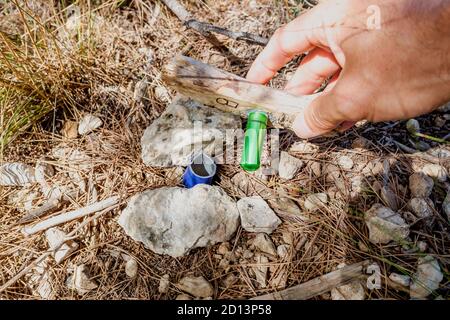 Geocache versteckt in einem Wald von Suchenden gefunden Stockfoto