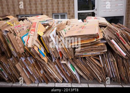 Zerlegte und gebündelte Kartons liegen auf dem Bürgersteig zur Entsorgung, Köln, Deutschland. Zerlegte und gebuendelte Pappkartons liegen zum Abtransport Stockfoto