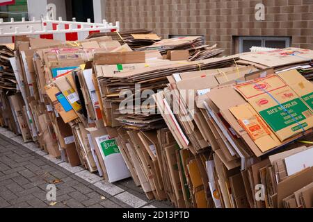 Zerlegte und gebündelte Kartons liegen auf dem Bürgersteig zur Entsorgung, Köln, Deutschland. Zerlegte und gebuendelte Pappkartons liegen zum Abtransport Stockfoto