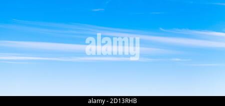 Blauer Himmel mit Streifen von weißen Cirrus Wolken am Tag, natürliche Panorama Hintergrund Foto Textur Stockfoto